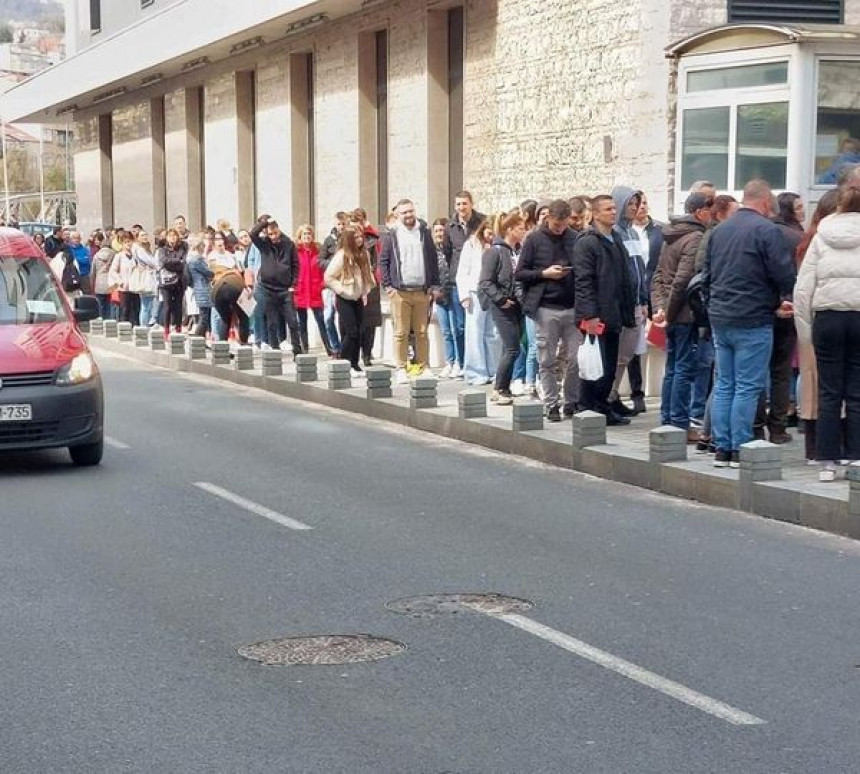 Колона људи чека испред њемачке амбасаде